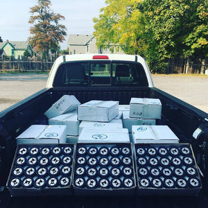 Boxes of hockey puck bottle openers in truck bed