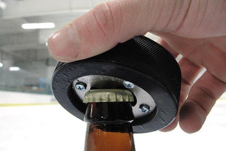 Hockey Puck Bottle Opener in use at ice rink
